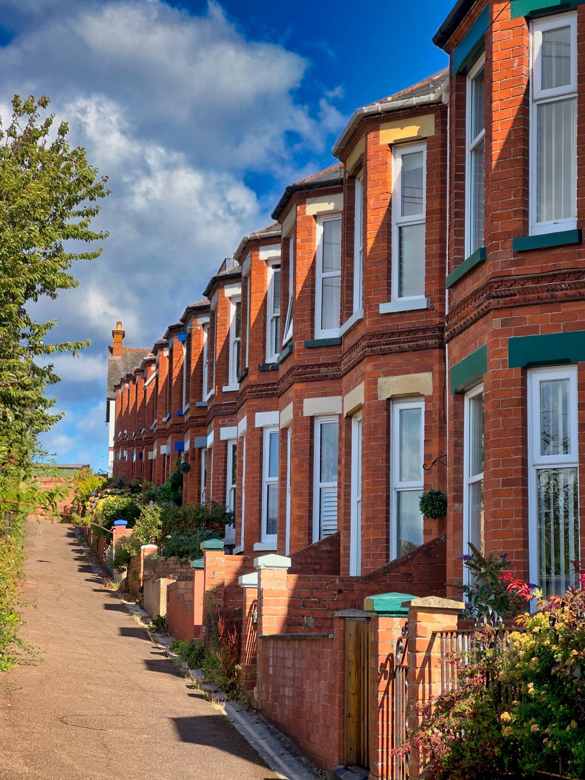 Red brick Victorian terraced houses on a steep street in England